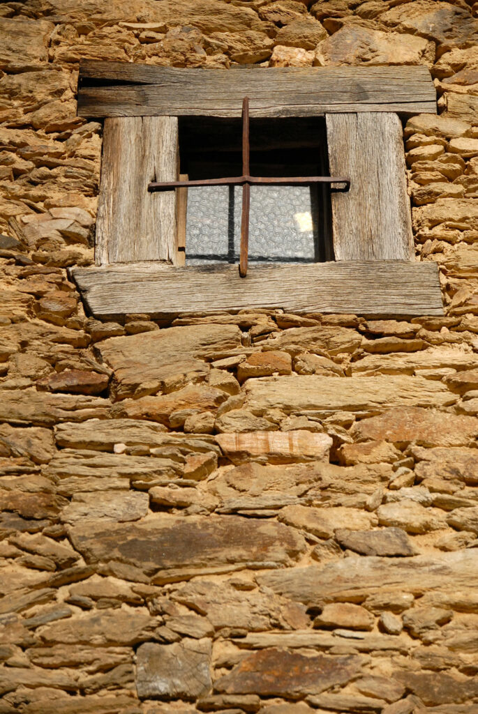Ventana en fachada de piedra de Sierra Norte